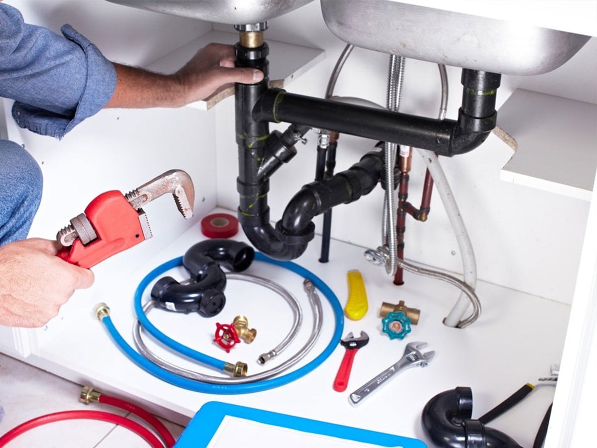 Plumber performing pipe repair